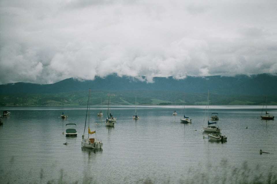 Boats at anchor in a sheltered bay under low cloud.